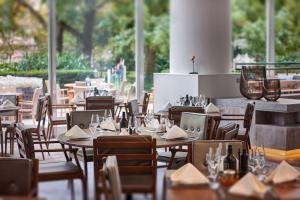 美因河畔法兰克福法兰克福市中心希尔顿酒店的配有木桌和椅子的餐厅