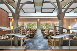 美因河畔法兰克福法兰克福市中心希尔顿酒店的用餐室配有桌椅和大窗户