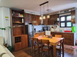 巴斯科Lorenzo's Homestay的带木桌的厨房和带冰箱的厨房。