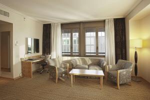 米兰希尔顿米兰酒店的客厅配有沙发、椅子和书桌