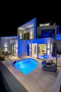 拉夫蒂港White Cliff Luxury Suites by A&D Properties的夜间带游泳池的别墅
