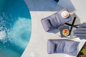 拉夫蒂港White Cliff Luxury Suites by A&D Properties的享有带紫色枕头的游泳池的顶部景致
