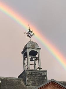 纽马基特The Courtyard的一座带钟楼建筑上的彩虹