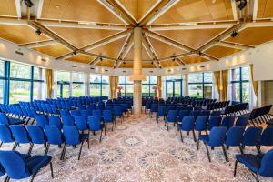 索斯图尼恩DoubleTree by Hilton Royal Parc Soestduinen的大房间设有蓝色椅子和大型天花板