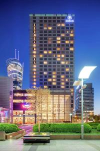 华沙Hilton Warsaw City Hotel的夜晚在城市的高楼