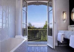 凡尔赛Waldorf Astoria Versailles - Trianon Palace的带浴缸的浴室和大窗户