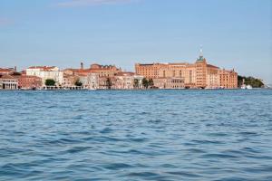 威尼斯威尼斯莫利诺斯塔基希尔顿酒店的一大片水体,有建筑背景