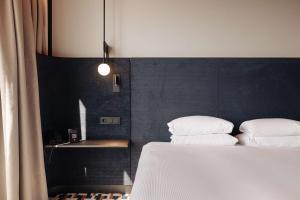 阿姆斯特丹阿姆斯特丹中央车站希尔顿逸林酒店的一间卧室配有一张带两个枕头的床