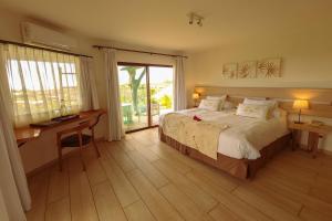 安加罗阿Hotel Hare Uta的一间卧室配有一张床、一张书桌和一个窗户。