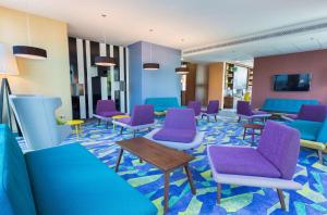 华沙华沙市中心希尔顿汉普顿酒店的一间设有蓝色和紫色椅子和桌子的等候室
