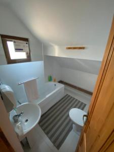 Pensiunea Agroturistica Casa Tarta的浴室配有盥洗盆、卫生间和浴缸。