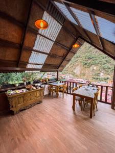 马丘比丘Rupa Rupa High Jungle Eco B&B的客房设有桌椅和大窗户。