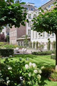 阿姆斯特丹阿姆斯特丹华尔道夫酒店的建筑前带长凳的公园