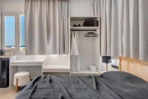 埃尔莫波利斯NOS Suites的一间卧室配有一张床、一张书桌和窗户。