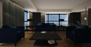 罗马Hilton Rome Eur La Lama的客厅配有蓝色的椅子和桌子