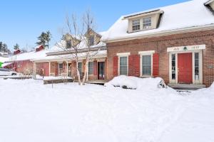 斯托Stowe Mountain Road Escape的一座红砖房子,地面上积雪