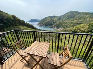 OtsukiHotel Bellreef Otsuki - Vacation STAY 43762v的俯瞰河流的阳台配有两把椅子和一张桌子