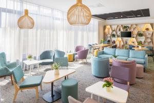 霍夫多普阿姆斯特丹史基浦机场希尔顿恒庭酒店的一间设有五颜六色的椅子和桌子的等候室