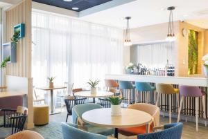 霍夫多普阿姆斯特丹史基浦机场希尔顿恒庭酒店的一间带桌椅的餐厅和一间酒吧