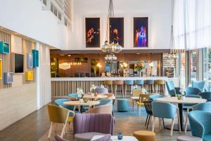 阿姆斯特丹Hampton By Hilton Amsterdam Arena Boulevard的一间带桌椅的餐厅和一间酒吧