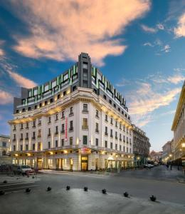 布加勒斯特Hilton Garden Inn Bucharest Old Town的黄昏时分,在城市街道上一座白色的大建筑