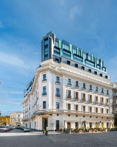 布加勒斯特Hilton Garden Inn Bucharest Old Town的一条大白色的建筑,坐在街道的顶部