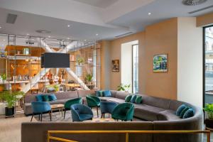 布加勒斯特Hilton Garden Inn Bucharest Old Town的大堂配有沙发、椅子和电视