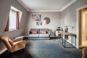 布鲁塞尔布鲁塞尔大广场希尔顿酒店的客厅配有沙发和桌子