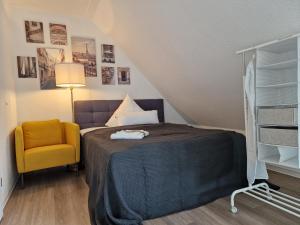 比勒费尔德Modern-Living Stadt-Appartement Mitte的一间卧室配有一张床和一张黄色椅子