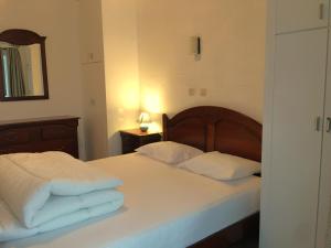 尼乌波特Vakantieappartement "The Seagull" vlakbij het strand的一间卧室配有一张带白色床单和镜子的床