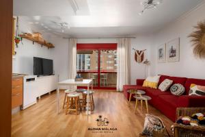马拉加Apartamento Imperio Argentina的一间带红色沙发的客厅和一间厨房