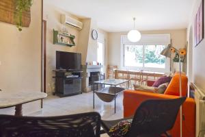 卡斯特尔德费尔斯维达古尔度假屋的客厅配有橙色沙发和桌子