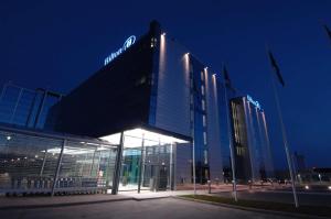 万塔赫尔辛基机场希尔顿酒店的一座建筑物,晚上在建筑物的一侧有标志
