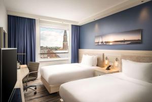 基尔Hampton By Hilton Kiel的酒店客房设有两张床和窗户。