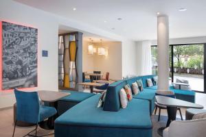 凯撒斯劳滕Hampton By Hilton Kaiserslautern的一间设有蓝色椅子和桌子的等候室