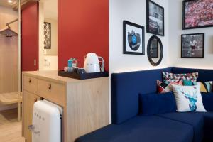 凯撒斯劳滕Hampton By Hilton Kaiserslautern的客厅配有蓝色的沙发和桌子
