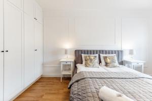 卢布林Aparthotel Plac Litewski Premium的一间卧室配有一张带白色橱柜的大床