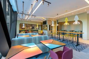 阿尔考本达斯Hampton By Hilton Alcobendas Madrid的一个带桌椅的大堂和一间餐厅