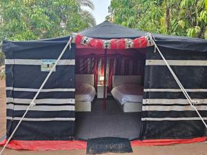 Al-DisahMango Farm Camp的黑色帐篷内配有两张床
