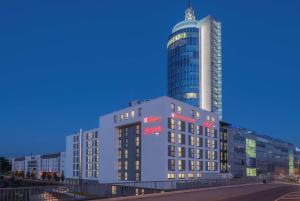 慕尼黑Hilton Garden Inn Munich City West的一座大建筑,背后是高耸的摩天大楼