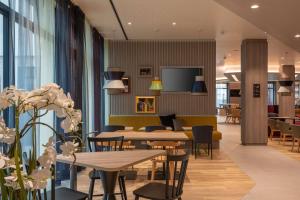 慕尼黑Hampton By Hilton Munich City North的用餐室设有桌椅和窗户。