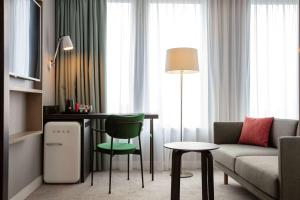 朗吉斯Hilton Garden Inn Paris Orly Airport的客厅配有沙发和桌椅