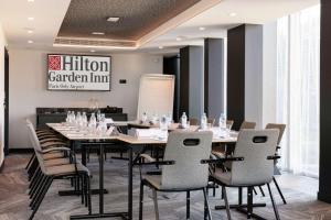 朗吉斯Hilton Garden Inn Paris Orly Airport的一间会议室,配有长桌子和椅子