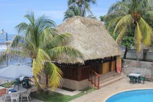 拉利伯塔德朋塔罗卡冲浪度假酒店的度假村旁的小屋设有游泳池