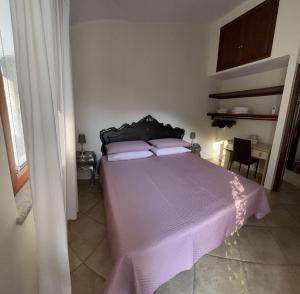卡拉古诺内B&B Easy Wind的一间卧室配有一张带紫色棉被的床
