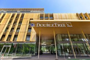 维也纳Doubletree by Hilton Vienna Schonbrunn的上面有双层树标的建筑