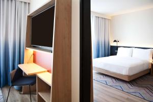 维也纳Hampton By Hilton Vienna Messe的配有一张床和一台平面电视的酒店客房