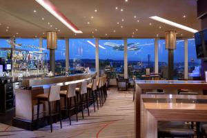 欧普菲康希尔顿苏黎世机场酒店的餐厅设有酒吧,享有城市美景