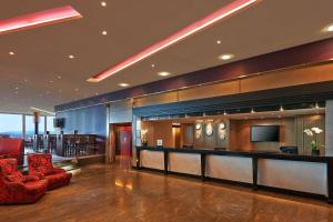 欧普菲康希尔顿苏黎世机场酒店的酒店大堂设有酒吧和红色椅子
