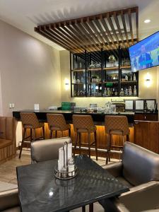 奇瓦瓦Best Western Plus Chihuahua Juventud的餐厅设有酒吧,配有椅子和桌子